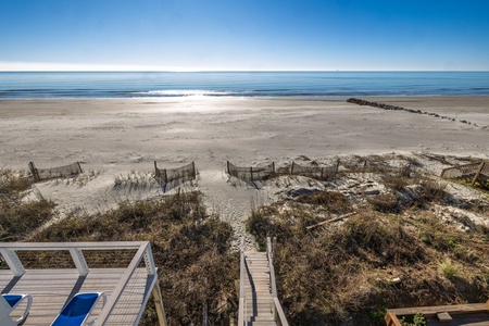 Pristine beachfront stretches endlessly before this coastal retreat, offering direct access to sandy shores and sparkling ocean waves.