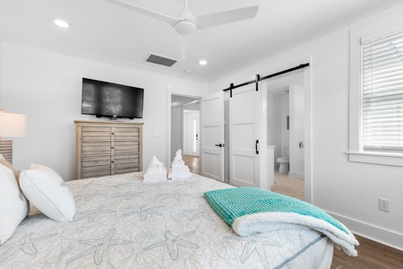 Your primary king bedroom features an en suite bathroom, separated by a rustic barn door