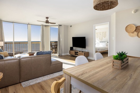 Unwind in your beachfront living space where natural textures meet ocean views. Large windows frame the sea while you relax on plush seating.