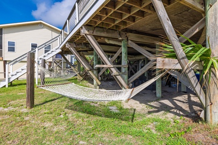 Sway gently in your private hammock beneath the raised coastal home, where sea breezes and tropical plants create a peaceful retreat perfect for lazy afternoons.