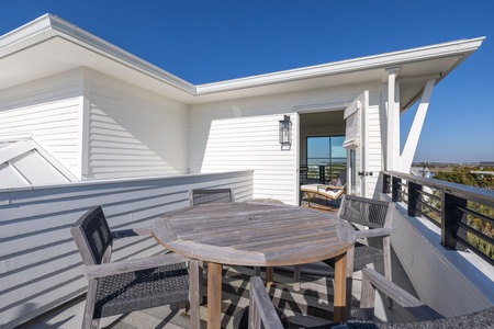 Spacious rooftop terrace with dining table and panoramic views across the surrounding landscape.
