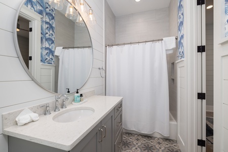 The king en suite has a tub-shower combo and coastal touches