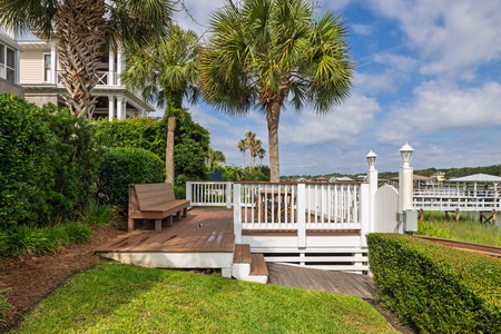 Private deck overlooking the water and marina, surrounded by tropical palms and lush landscaping—an ideal spot to unwind with morning coffee or evening sunsets.