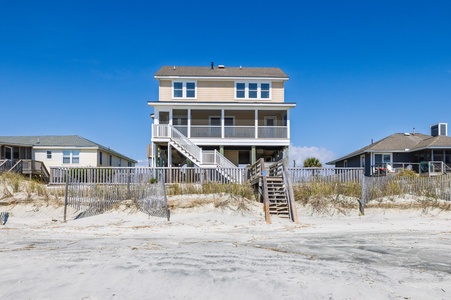 Beachfront property with direct beach access and wooden stairs leading from the sand to elevated decks.