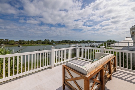 Picture yourself lounging on cushioned seats, overlooking serene waterfront views and lush greenery—your private retreat for morning coffee or sunset relaxation.