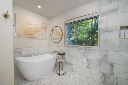 The spectacular primary en suite has a large soaking tub and glass walk-in shower