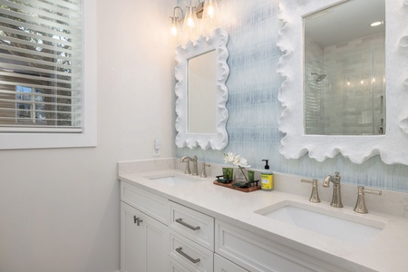 Your primary en suite bathroom features a dual vanity and beautifully tiled walk-in shower