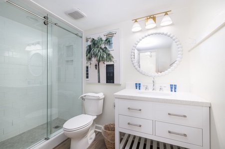 Step into your spa-like bathroom with elegant glass shower, marble vanity, and charming coastal artwork for relaxing mornings.