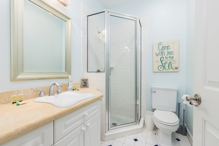 Refresh in your pristine bathroom with a spacious glass shower, elegant vanity, and charming coastal touches that make your getaway feel like home.