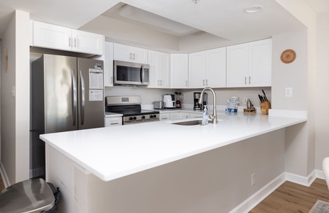 Your fully equipped kitchen features pristine white counters, stainless steel appliances, and everything you need to create delicious meals during your stay.