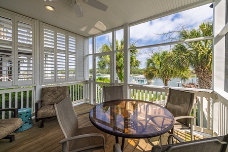 Picture yourself sipping morning coffee on your screened porch, where ceiling fans keep you comfortable while you enjoy waterfront views framed by swaying palms and serene marina scenes.