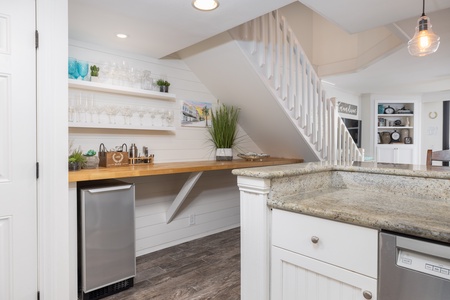 Your fully equipped kitchen features granite countertops, stainless steel appliances, and warm pendant lighting—perfect for preparing meals together.