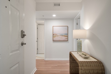 Step into your bright, welcoming entryway with warm wood floors and coastal artwork that sets a relaxing tone for your stay.