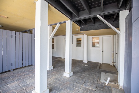 Spacious covered entryway with architectural columns and stone flooring leads to your vacation rental's front door.