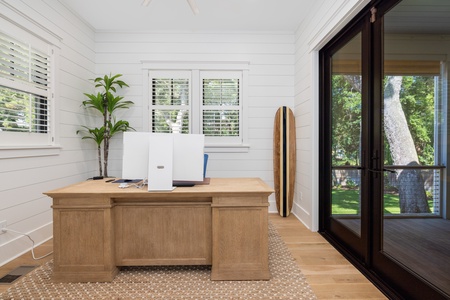 The first floor workspace offers access to the deck and a view of the pool