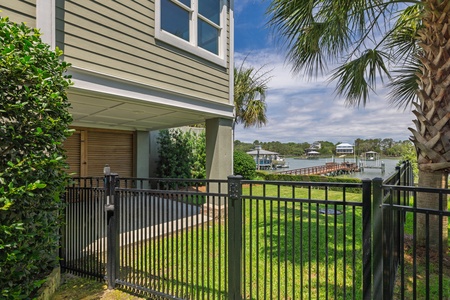 Waterfront property features peaceful river views and boat access along a tree-lined shoreline with neighboring homes and docks visible across the calm waters.