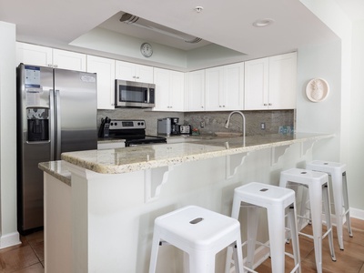 Your sleek modern kitchen features granite counters, stainless appliances, and a breakfast bar perfect for morning coffee with friends.