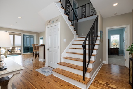 Enter to the beautiful entryway with warm wood and wrought iron staircase