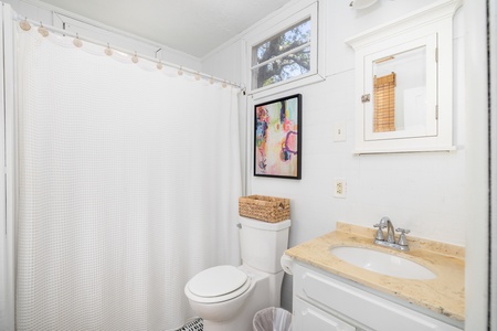 The queen en suite bathroom features a tub-shower combo
