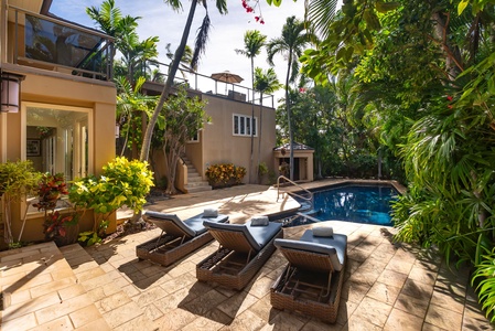 Your private tropical oasis awaits with a sparkling pool surrounded by lush palms and comfortable loungers for perfect relaxation.