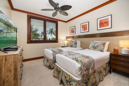 The third guest bedroom features twin beds and colorful framed artwork, reflecting the vibrant energy of Hawaii.