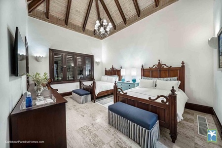 Beautifully designed guest bedroom with classic wooden furnishings and two beds.
