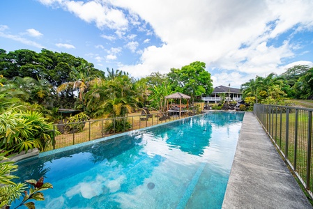 Sparkling private lap-style pool surrounded by lush greenery—perfect for swimming laps or lounging under the island sun.
