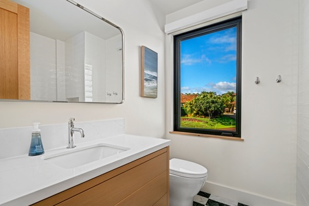 Convenient full bathroom in the media room with garden views through the large window.