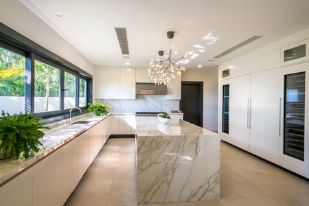 Sleek and modern kitchen with marble countertops, high-end appliances, and ample natural light.