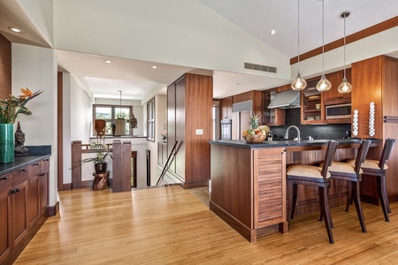 Wider view of upper level with bar seating into the open floor plan kitchen.