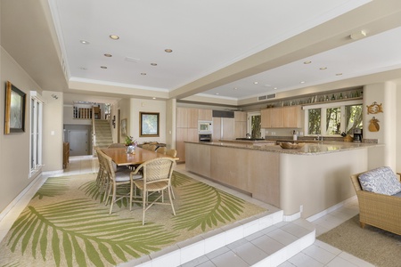 Dining area with kitchen access and coastal tones—perfect for shared meals with a view.
