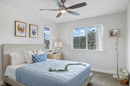 Cozy guest bedroom offers a queen bed, ample windows, and cool AC comfort.