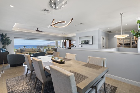 Dine with family under a modern chandelier and ocean views at Wailea Luxury Residence Hoolei 23-3.
