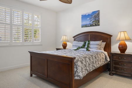 Retreat to the spacious primary bedroom featuring a king bed, plantation shutters, and a calm, restful atmosphere.
