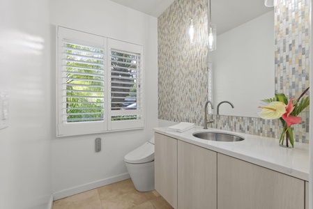 A stylish bathroom with textured tile and modern fixtures creates a soothing, elevated experience for guests.