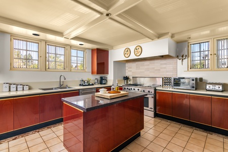 Formal living room with grand piano and soaring beamed ceilings.