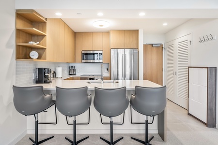 Modern kitchen with a sleek island and comfortable bar seating for casual dining.