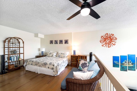 Airy loft at Kona Alii 512 with bed and lounge chair.