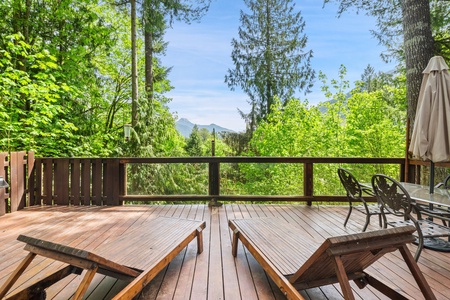 Enjoy your morning coffee on the deck with a serene view of the surrounding forest and mountains.