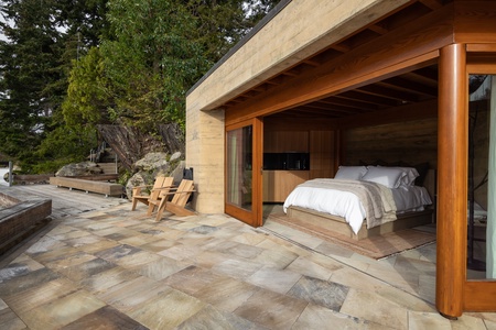 Modern lakeside suite with floor-to-ceiling windows and outdoor access.