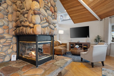 Cozy up by your stone fireplace while enjoying entertainment on the large TV in this inviting living space.