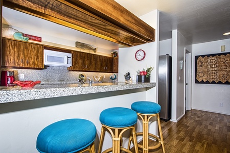 Granite breakfast bar with rattan stools, perfect for morning coffee or casual dining.