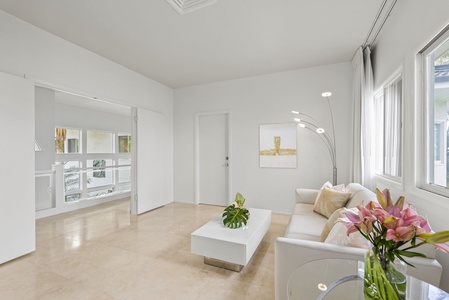 A guest lounge filled with coastal tones and plush seating—ideal for private conversations or downtime away from the group.