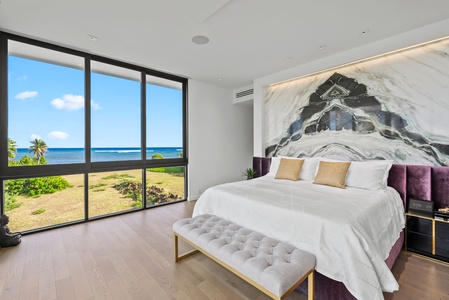 This sunlit primary suite features natural tones, ocean breezes, and a seating bench for serene morning rituals.