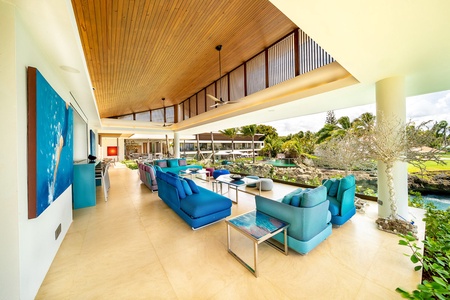 Relax in the vibrant, open-air second living area, adorned with plush blue seating.