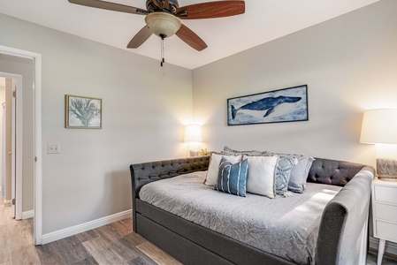 Guest bedroom with ceiling fan and calming coastal tones.