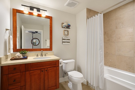 Guest bathroom with a tub/shower combo and storage.