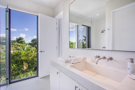 Ensuite bathroom with a beautiful view of the surrounding greenery.