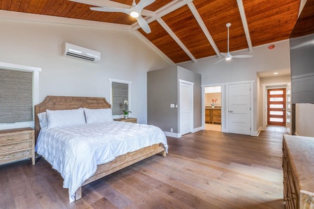 A spacious junior suite at Lani Oasis features a king bed, natural light, and ensuite bath access.