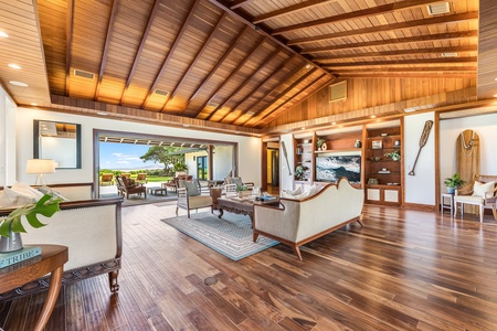 Elegant living area with vaulted wood ceilings and seamless flow to the lanai and ocean beyond.
